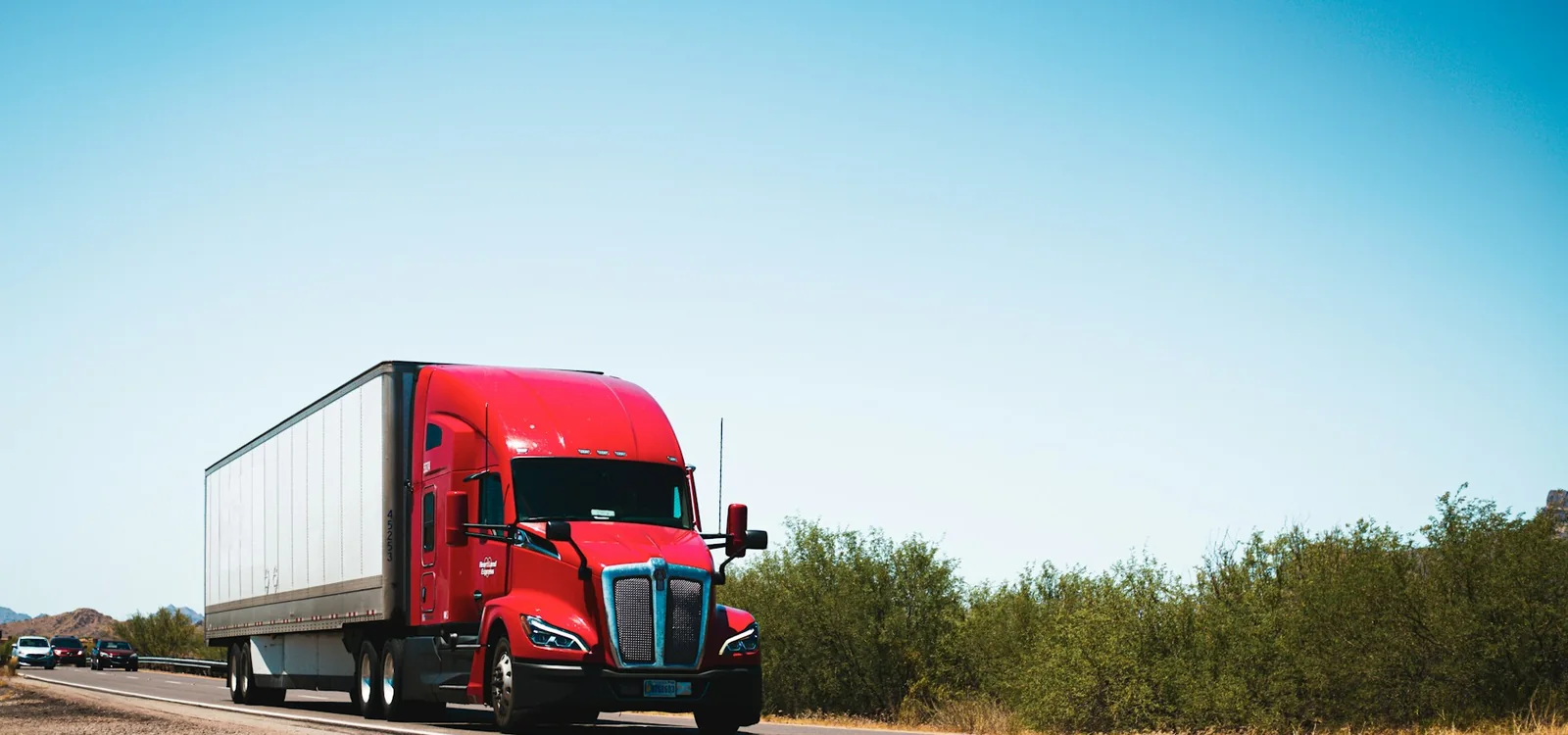 Caminhão vermelho em uma rodovia, representando o transporte de cargas
